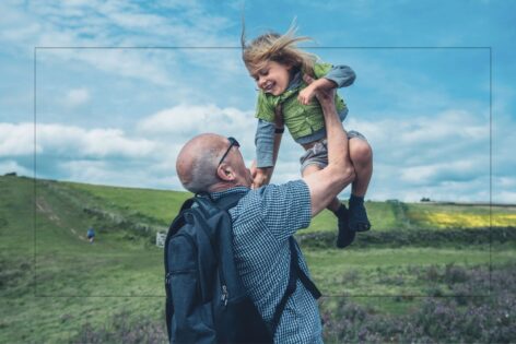 Grandpa lifts grandchild above his head.