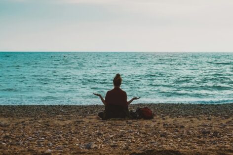 Woman meditates on the beach